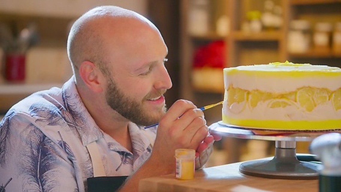 Nathan Chandler hand-painting lemon details onto a cake on Netflix’s Blue Ribbon Baking Championship